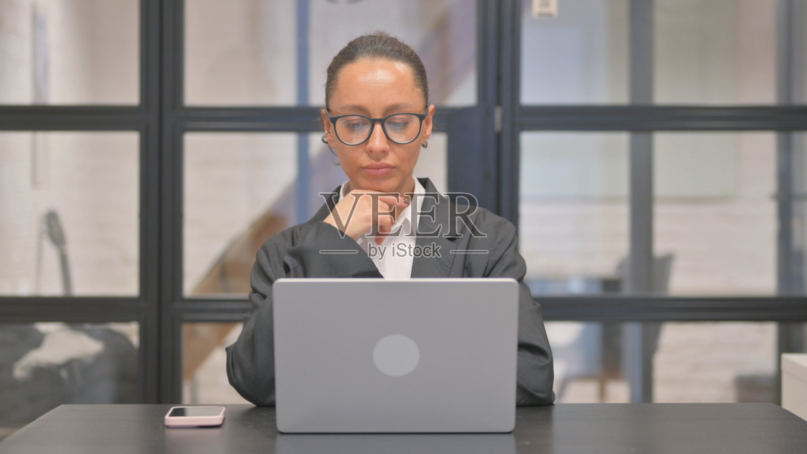 沉思的混血女商人在工作中进行头脑风暴照片摄影图片