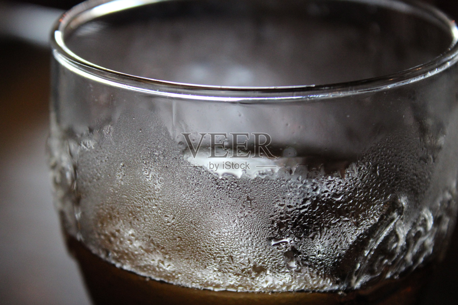 品脱玻璃杯里装满了冷饮，近距离观察，玻璃上可见冷凝物照片摄影图片