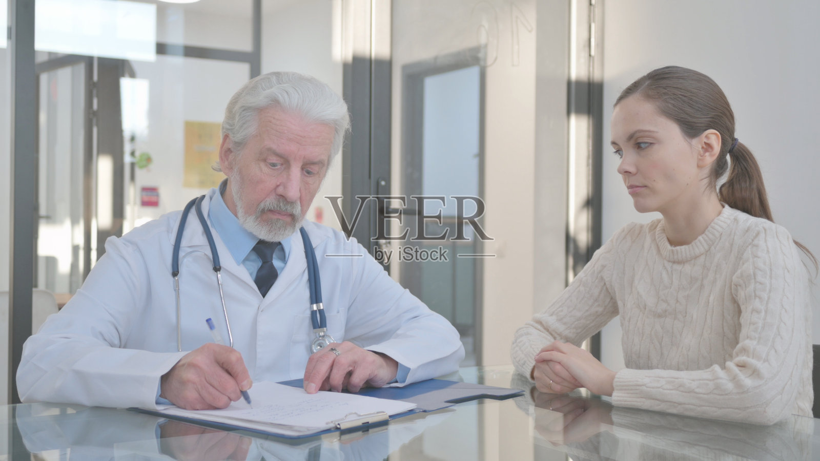 高级医生在诊所与妇女交谈照片摄影图片