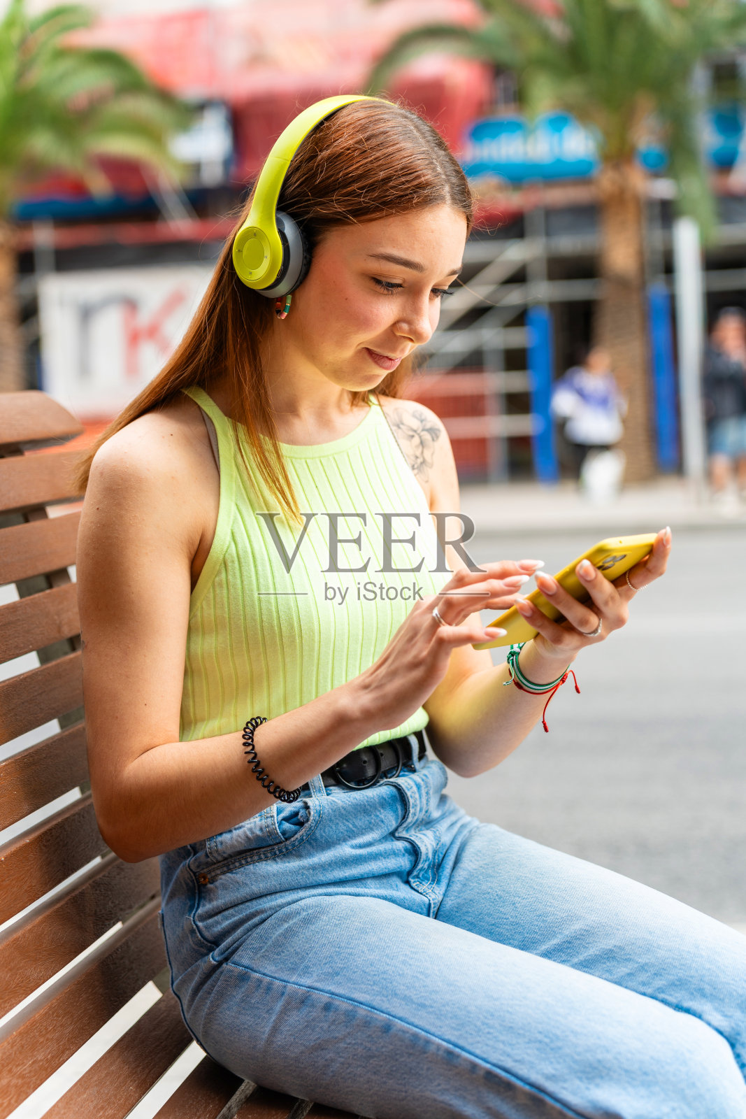 戴着耳机使用手机的大学生照片摄影图片