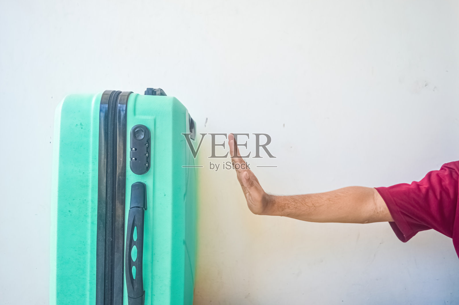 手停住了青绿色的手提箱照片摄影图片