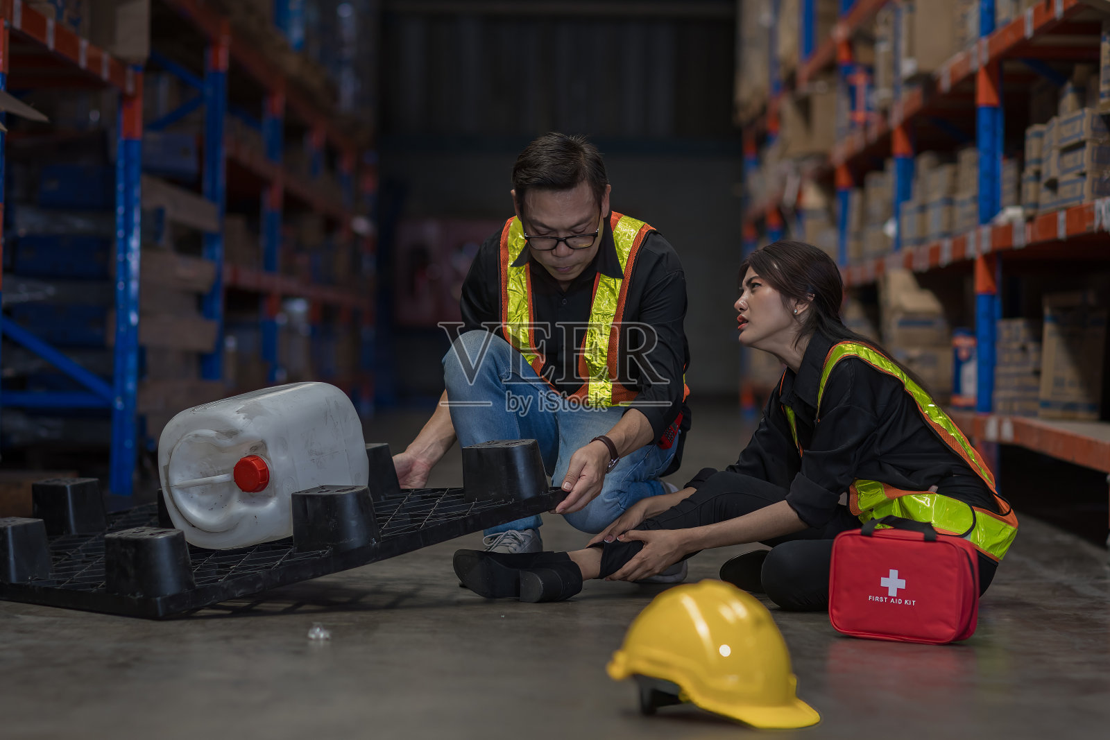 工厂工人工作事故的急救支持。男工人在仓库现场地板上发生事故照片摄影图片