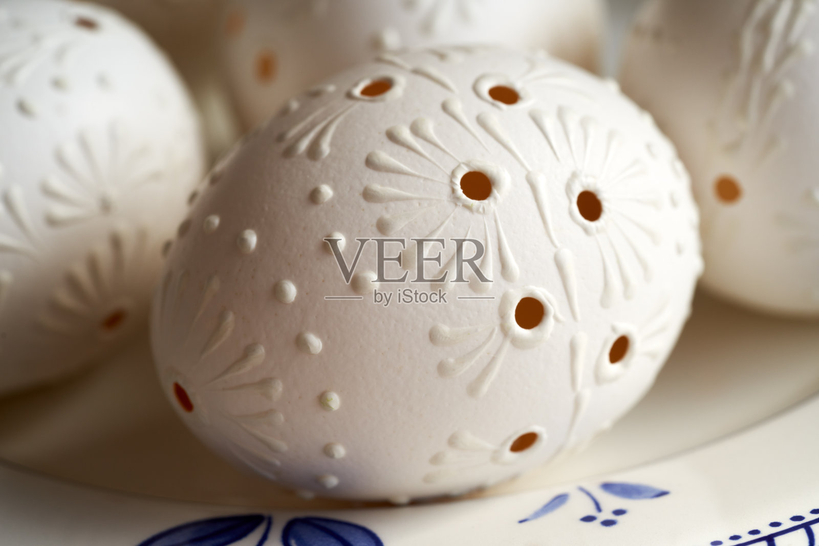 用蜡装饰的白色复活节彩蛋，上面有钻孔，近距离观察照片摄影图片