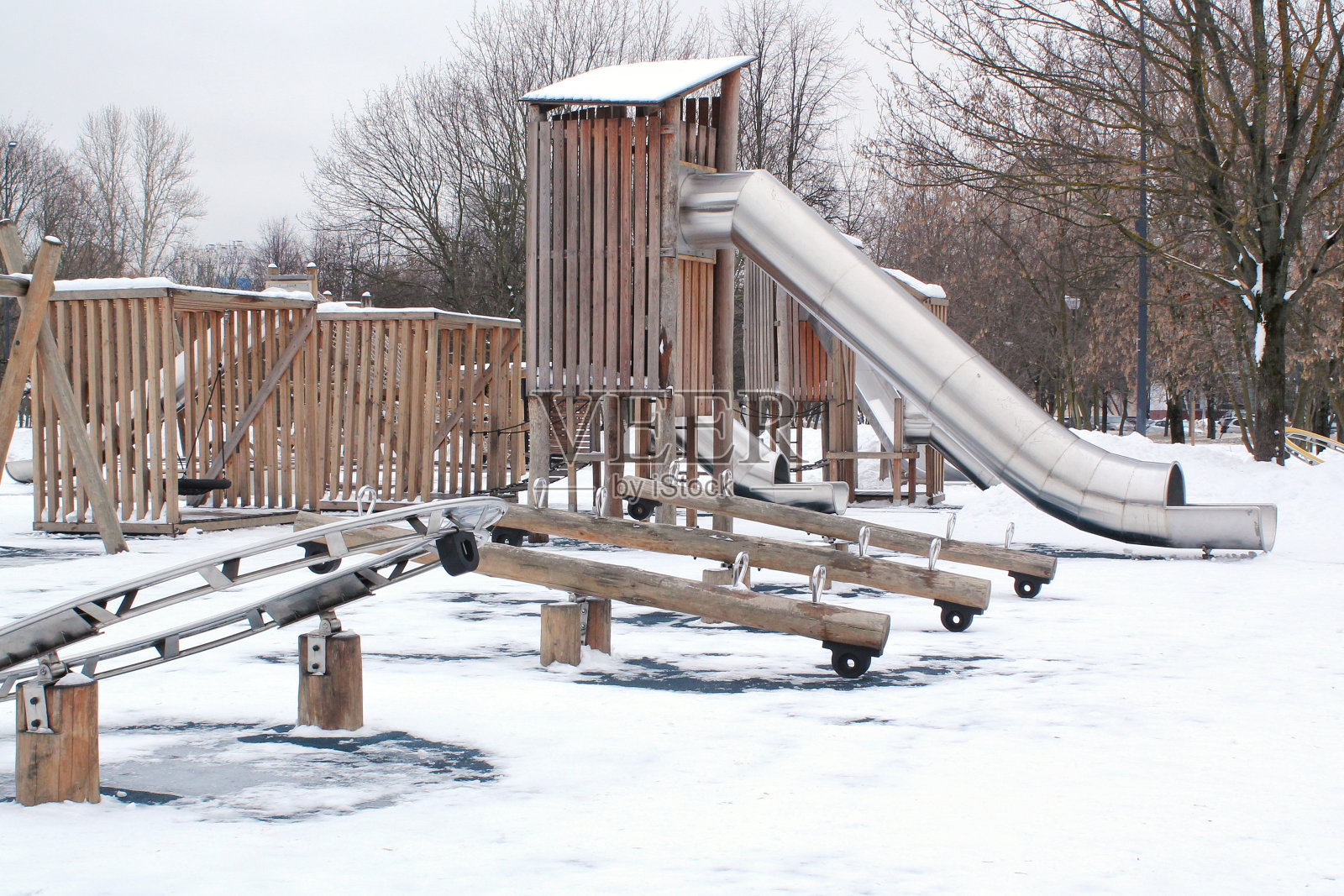 冬季有雪的城市公共公园，用天然环保材料制作的木制游乐场。现代安全儿童户外装备。冬季活动。孩子们在露天休息和做游戏照片摄影图片