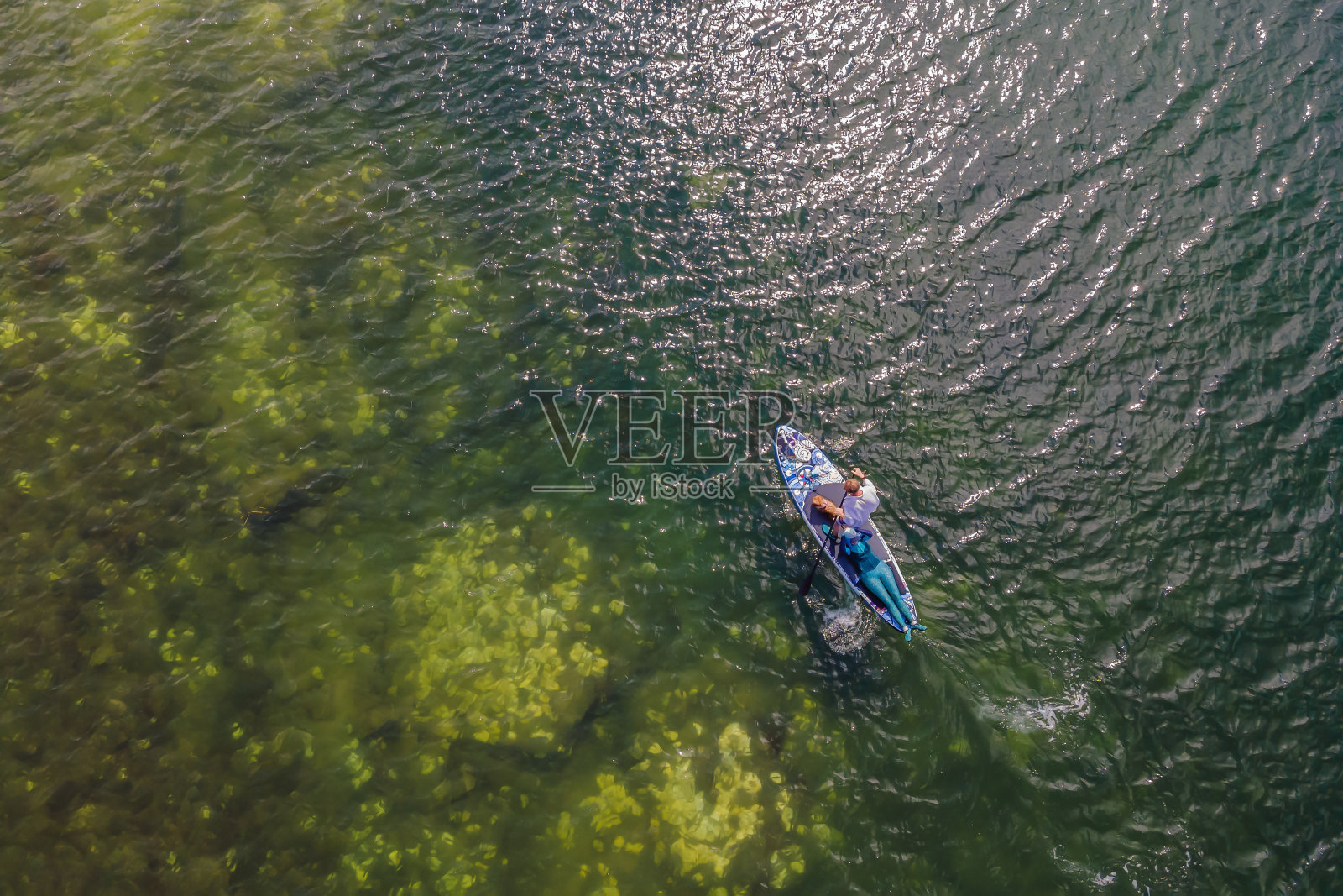 人站在一个平坦的温暖安静的海面上,与美丽的日落色彩照片摄影图片