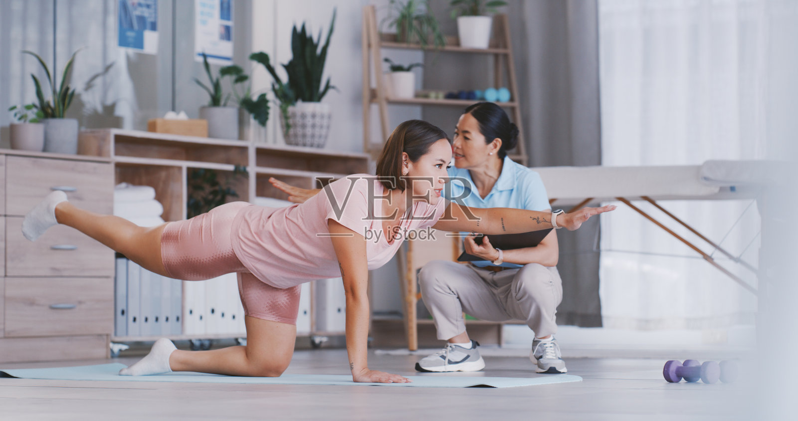 物理治疗师，妇女和地板进行运动或物理治疗以保持健康，并提供咨询和病人受伤的剪贴板。康复、脊医和腿部伸展康复和保健服务照片摄影图片