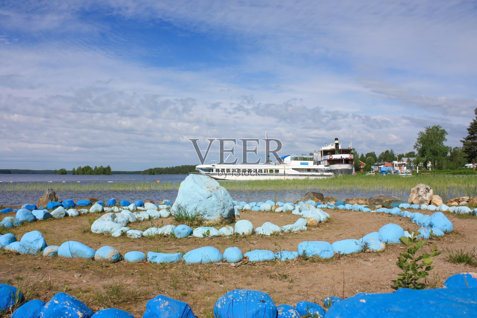 湖岸上排列着一圈蓝色的石头。照片摄影图片