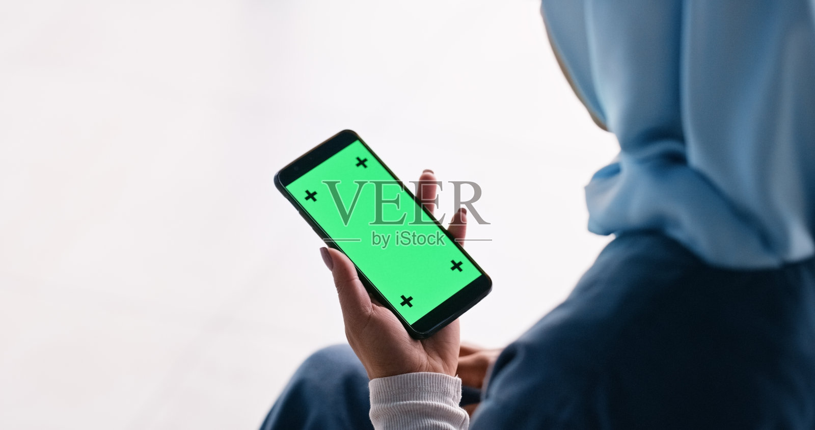 穆斯林妇女、护士和拿着手机或绿屏的手，用于远程医疗应用的广告或营销。戴着头巾的医疗保健女性在智能手机上为伊斯兰新闻、网站或模型空间拍照照片摄影图片