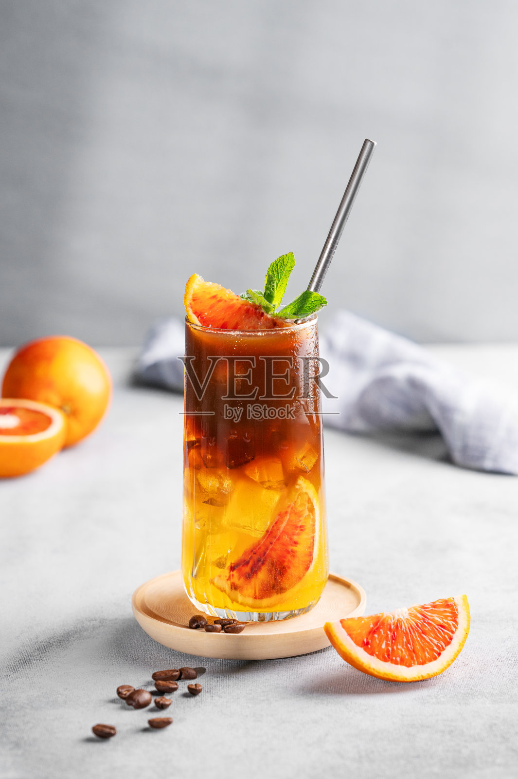 浓缩咖啡加橙汁(bumble)，装在高脚杯里，蓝色背景上加冰和薄荷照片摄影图片