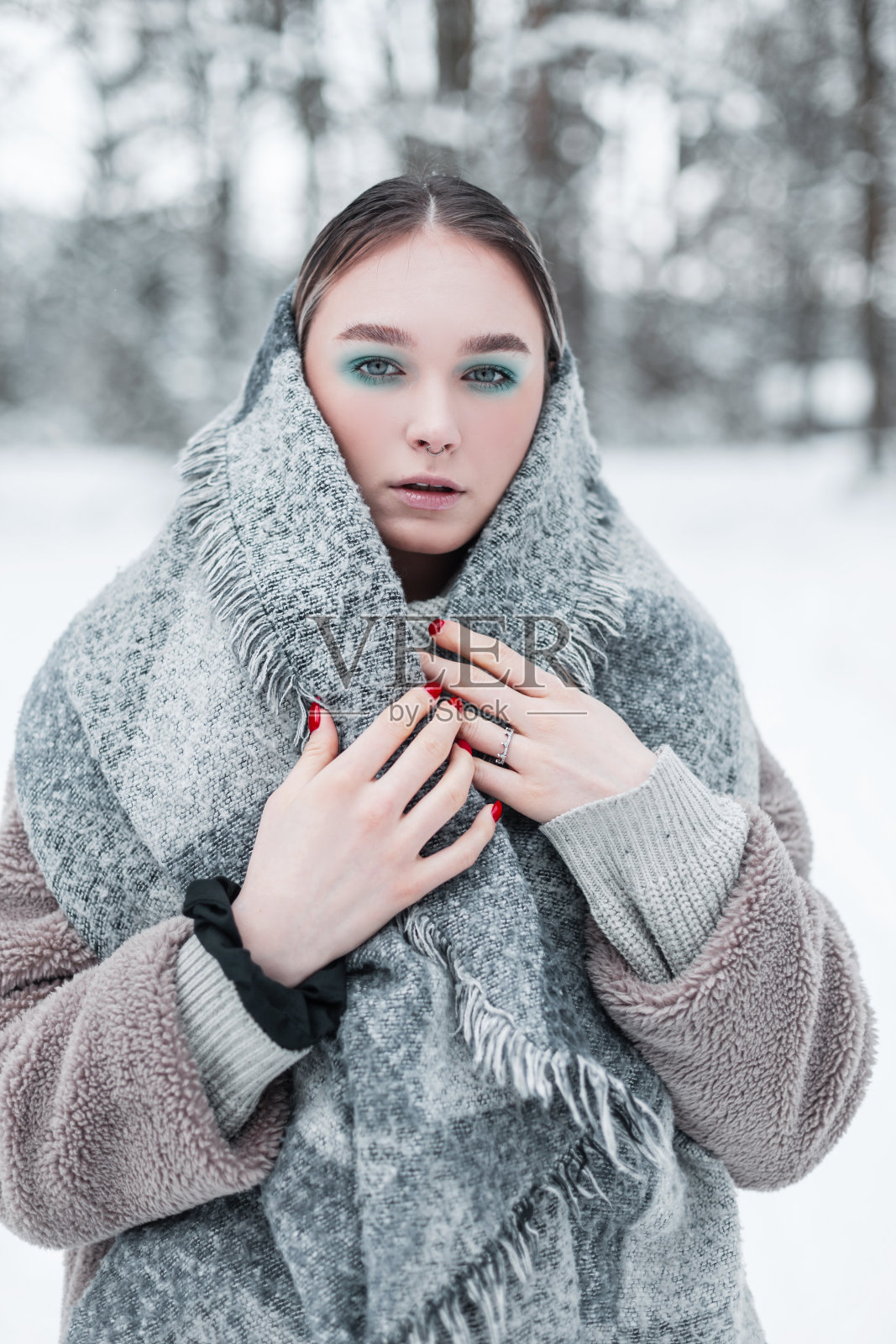 在一个下雪的寒冷的冬天，时尚美丽的年轻女性模特穿着冬天的衣服，戴着复古的围巾和毛皮大衣。俄罗斯女性冬季风格的外套照片摄影图片