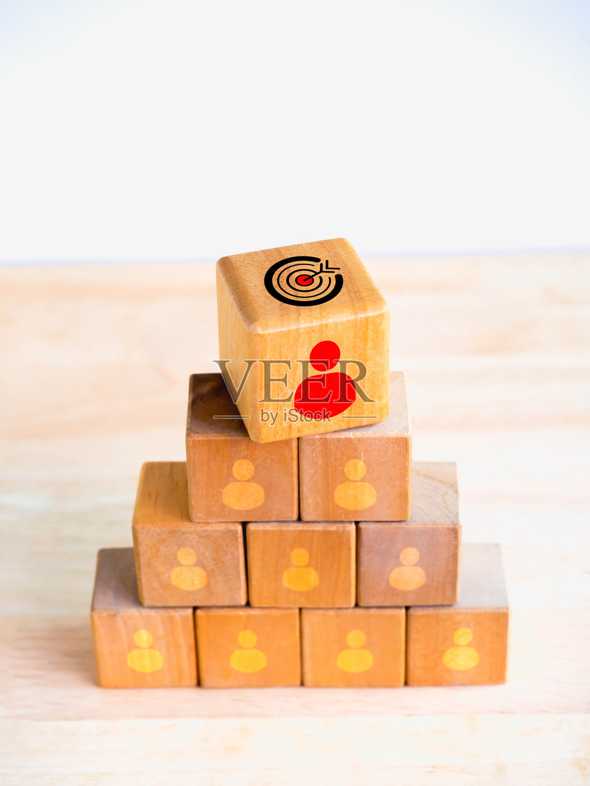 领导，领导，管理者，追随者，商业团队的概念。目标目标符号和红色的人图标在许多人的图标上的木块堆叠金字塔形状在白色垂直背景。照片摄影图片