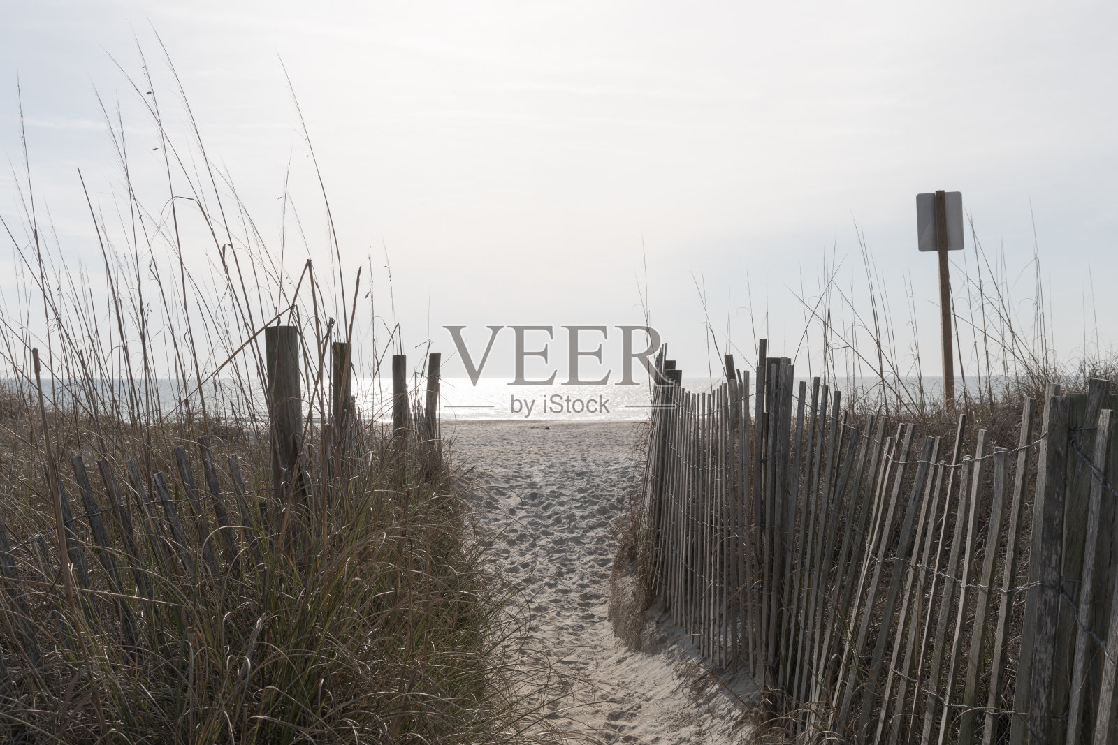 狭窄的小路穿过侵蚀栅栏，通往荒芜的开阔海滩，未来有无限的可能照片摄影图片