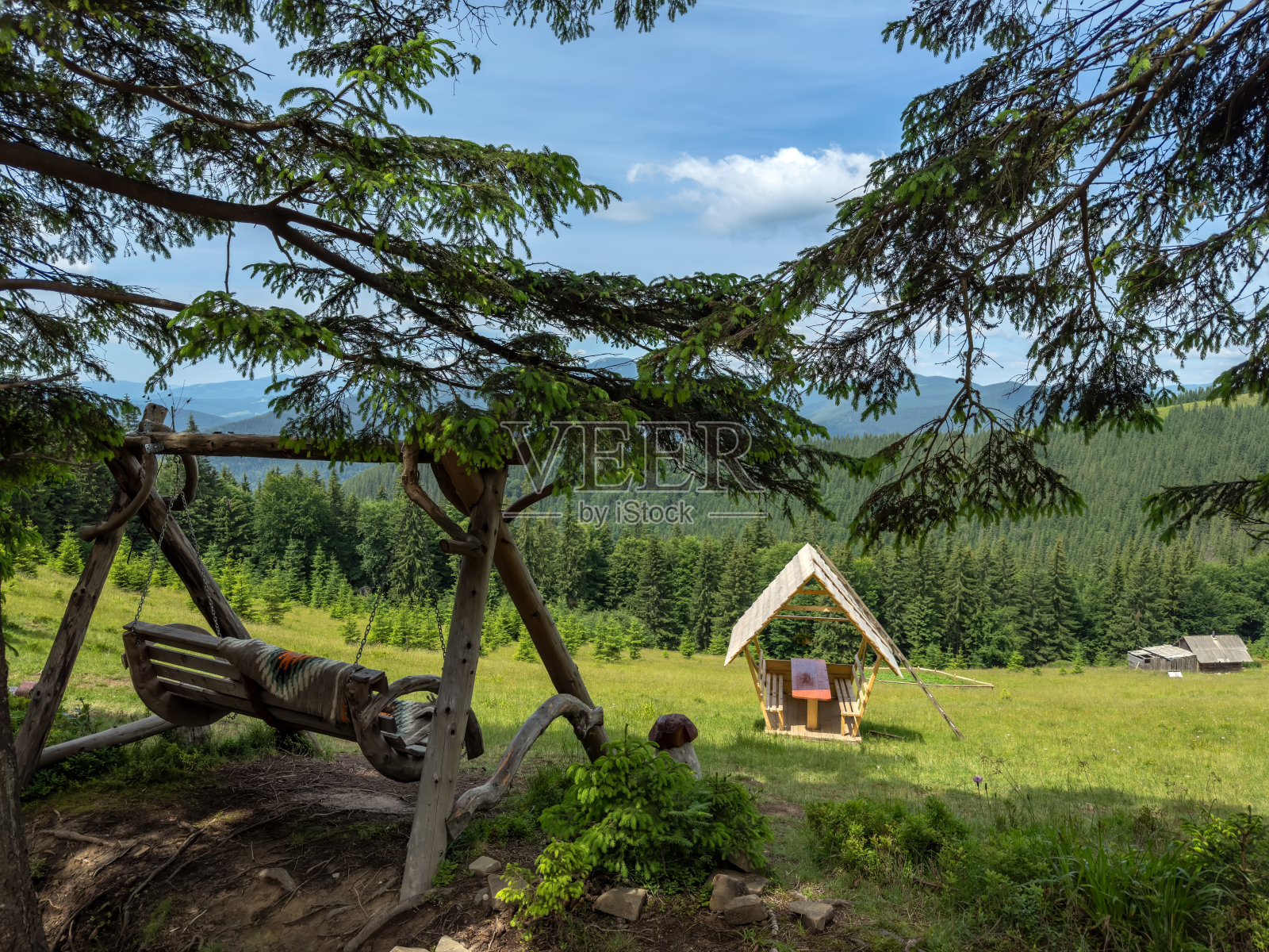 美丽的草坪景观，在山上放松，有秋千和凉亭。积极的生活方式，旅游、度假、远足、露营的理念。旅游健康生活理念。照片摄影图片