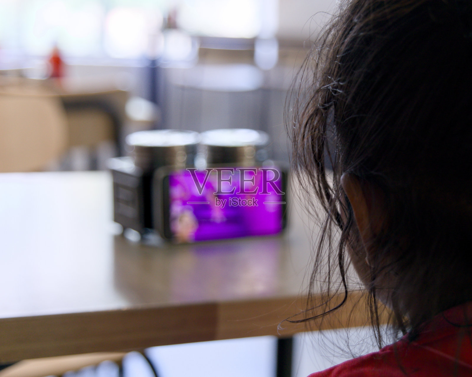 一个小女孩在商店里看手机的特写照片摄影图片