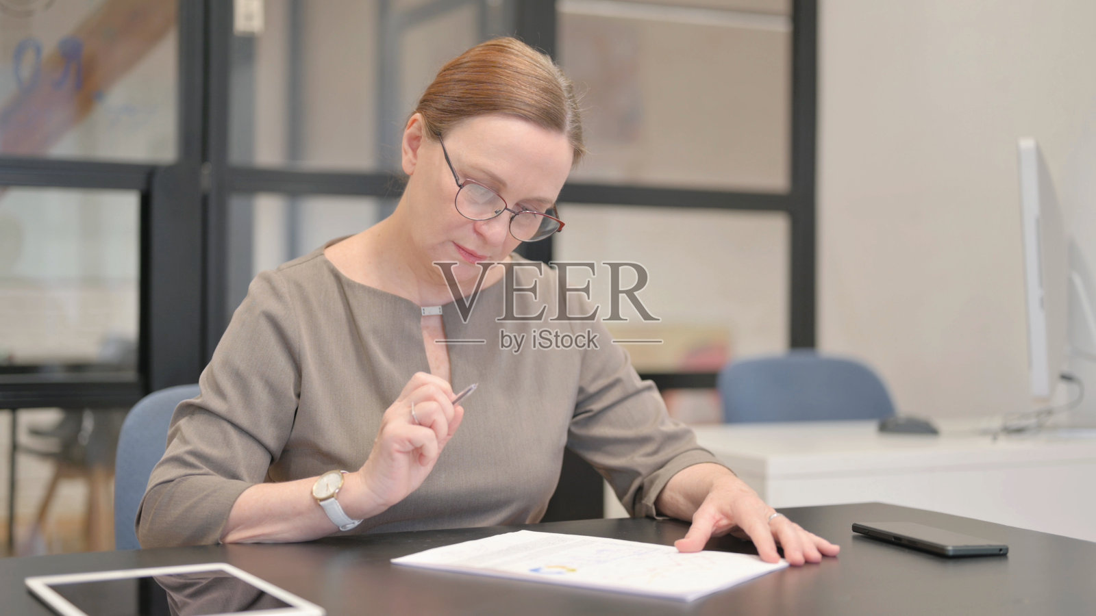 老女商人在办公室写信照片摄影图片