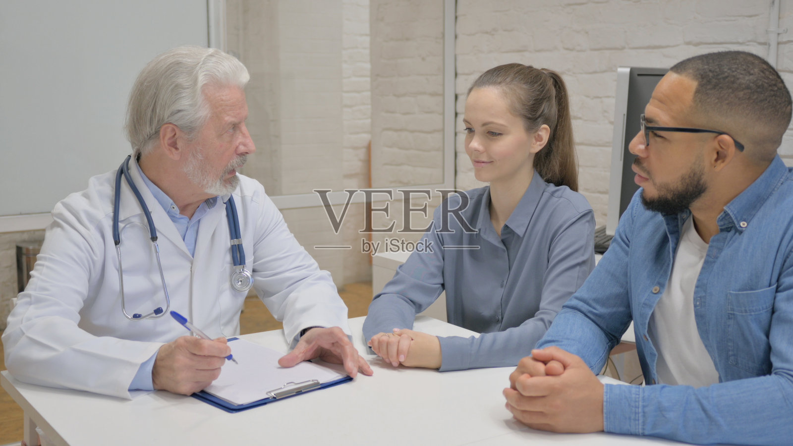 资深医生与夫妇谈话的后视图照片摄影图片