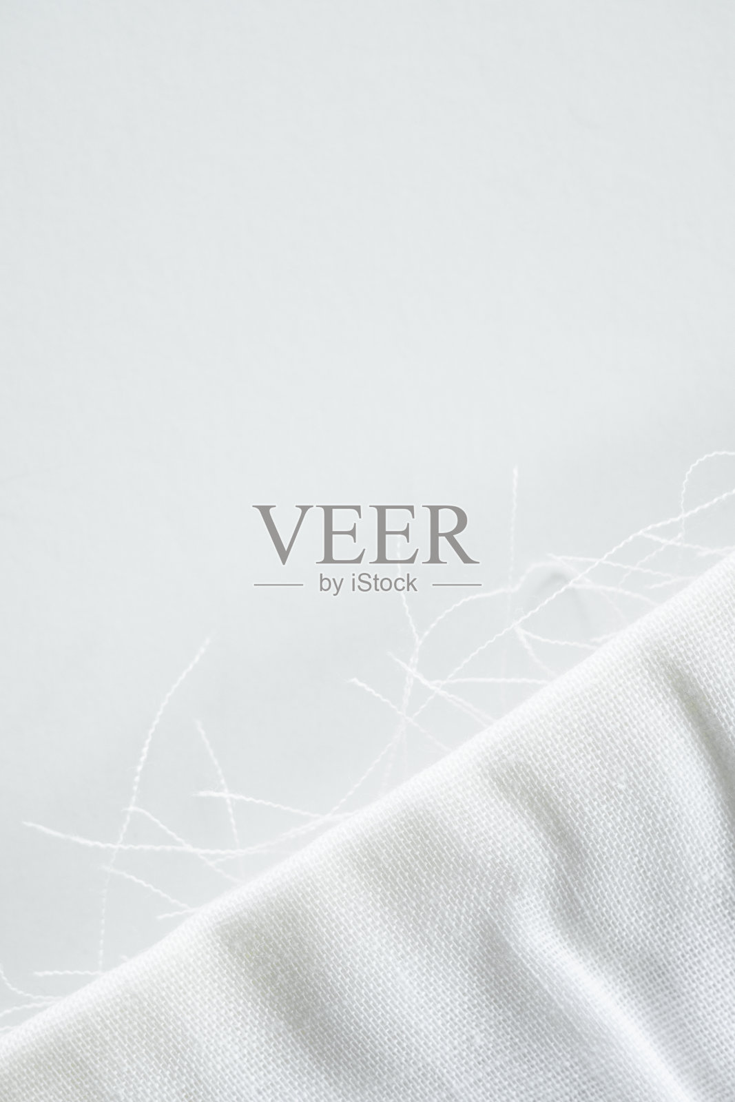 折叠的白色织物，边缘磨损，露出线照片摄影图片