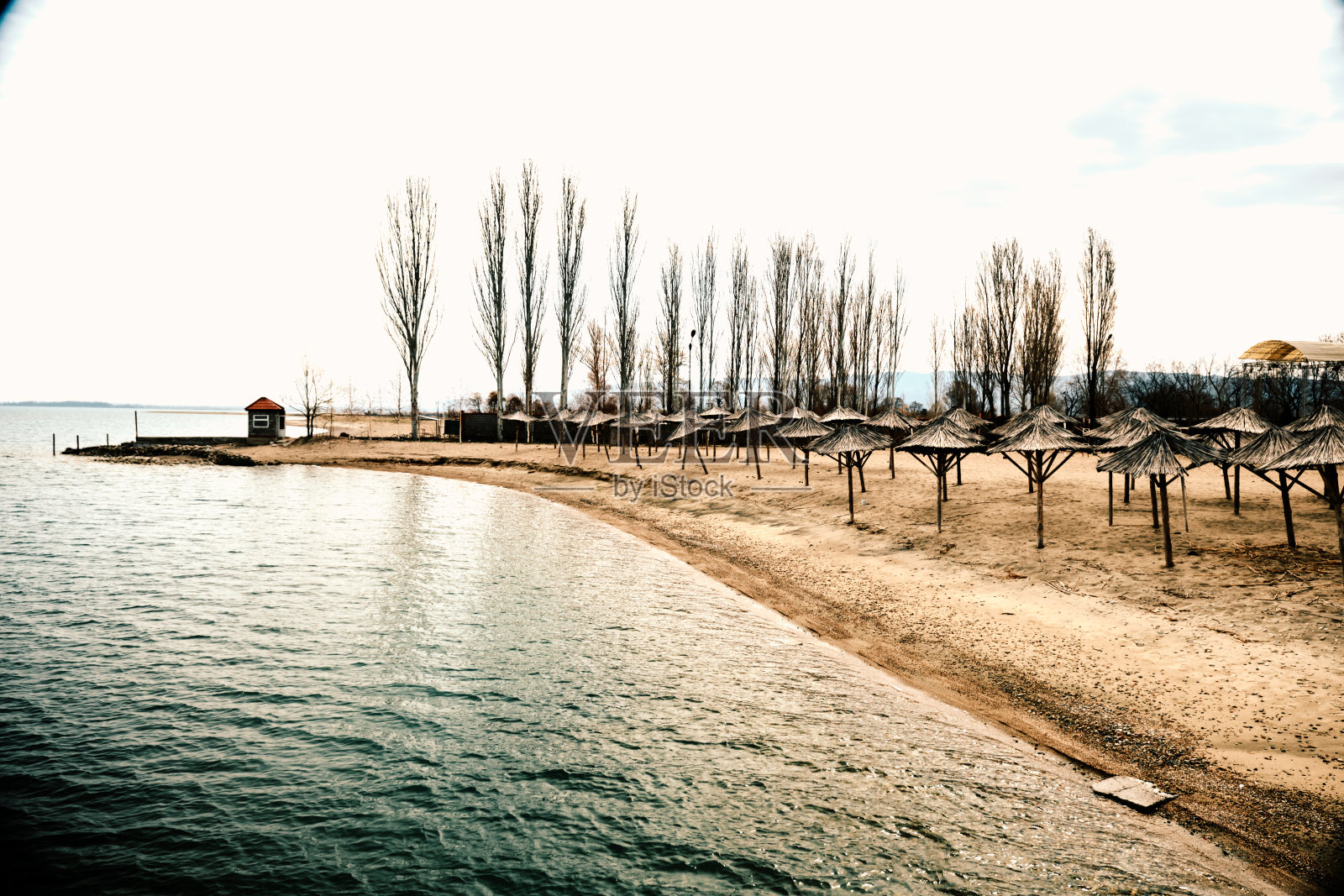 伊塞克库尔湖淡季海滩上的甘蔗遮阳伞照片摄影图片