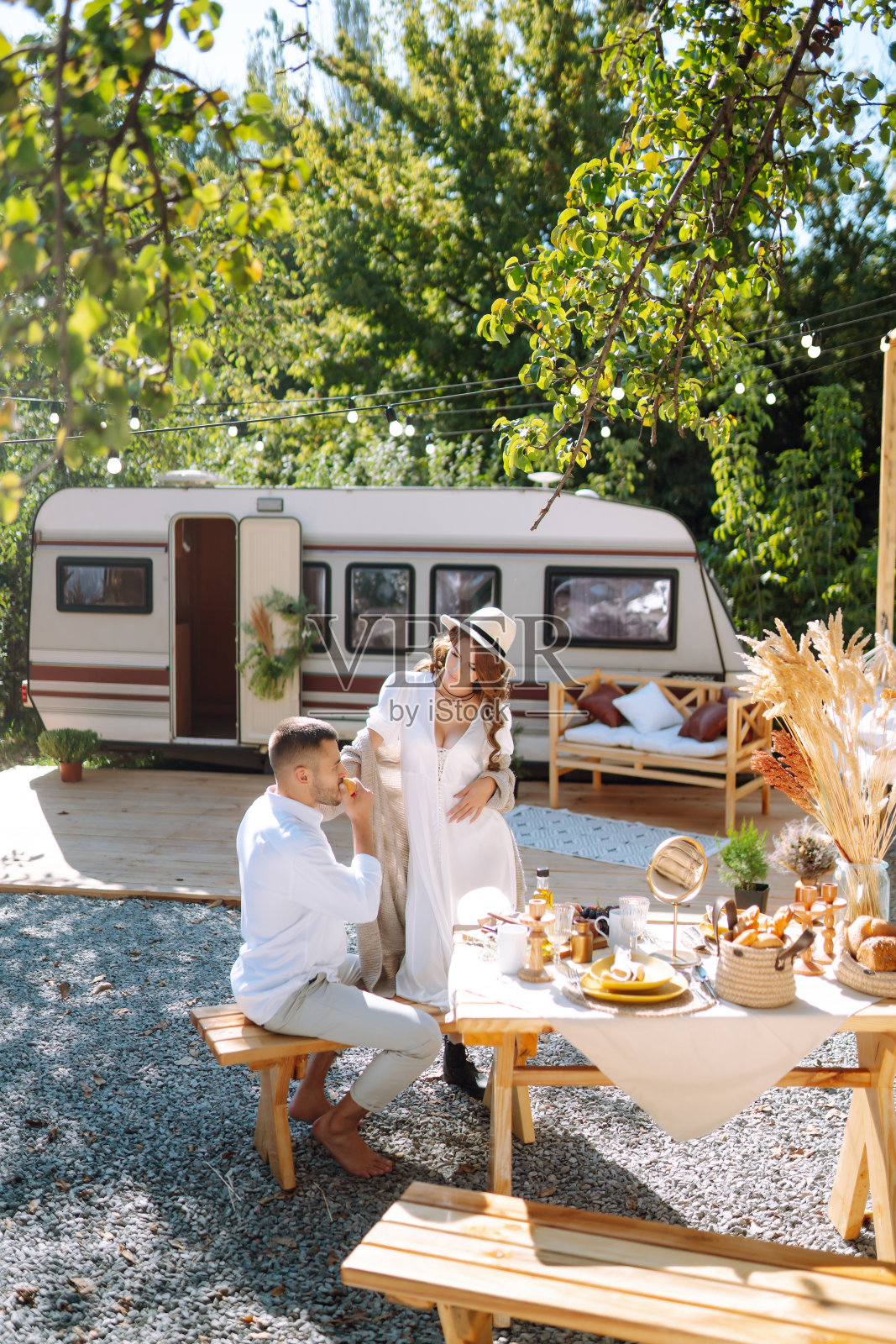 新婚夫妇温柔地拥抱，在面包车里享受彼此，在拖车里露营。照片摄影图片