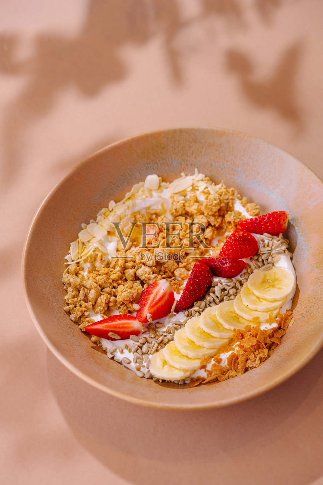 健康的格兰诺拉麦片早餐碗与水果浇头照片摄影图片