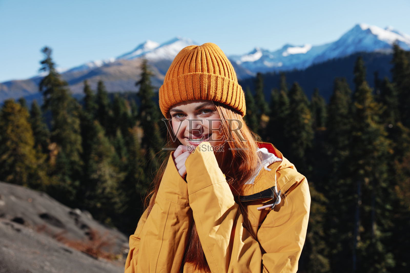 女人笑着笑着幸福和笑声旅游者穿着黄色的雨衣在秋天旅行，在日落的阳光下在山上徒步旅行自由照片摄影图片