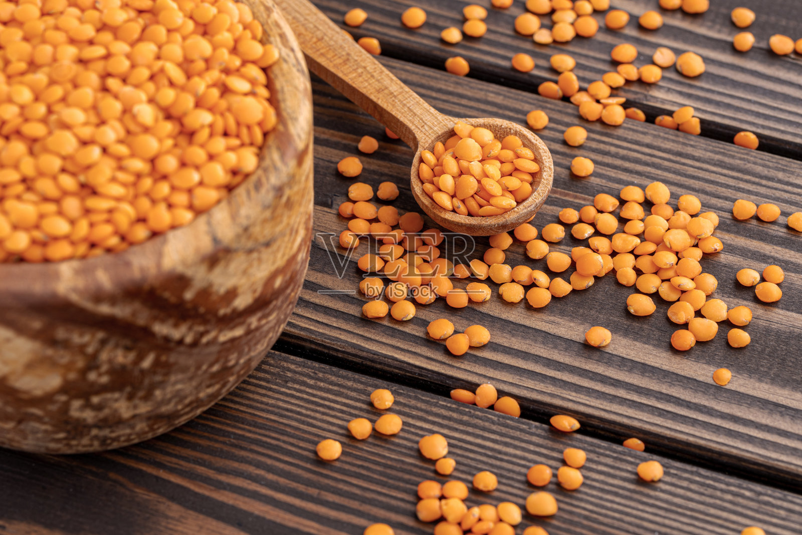 红色的小扁豆在木碗与木制的测量杯木制背景的照片。健康的生活方式。素食和纯素饮食。照片摄影图片