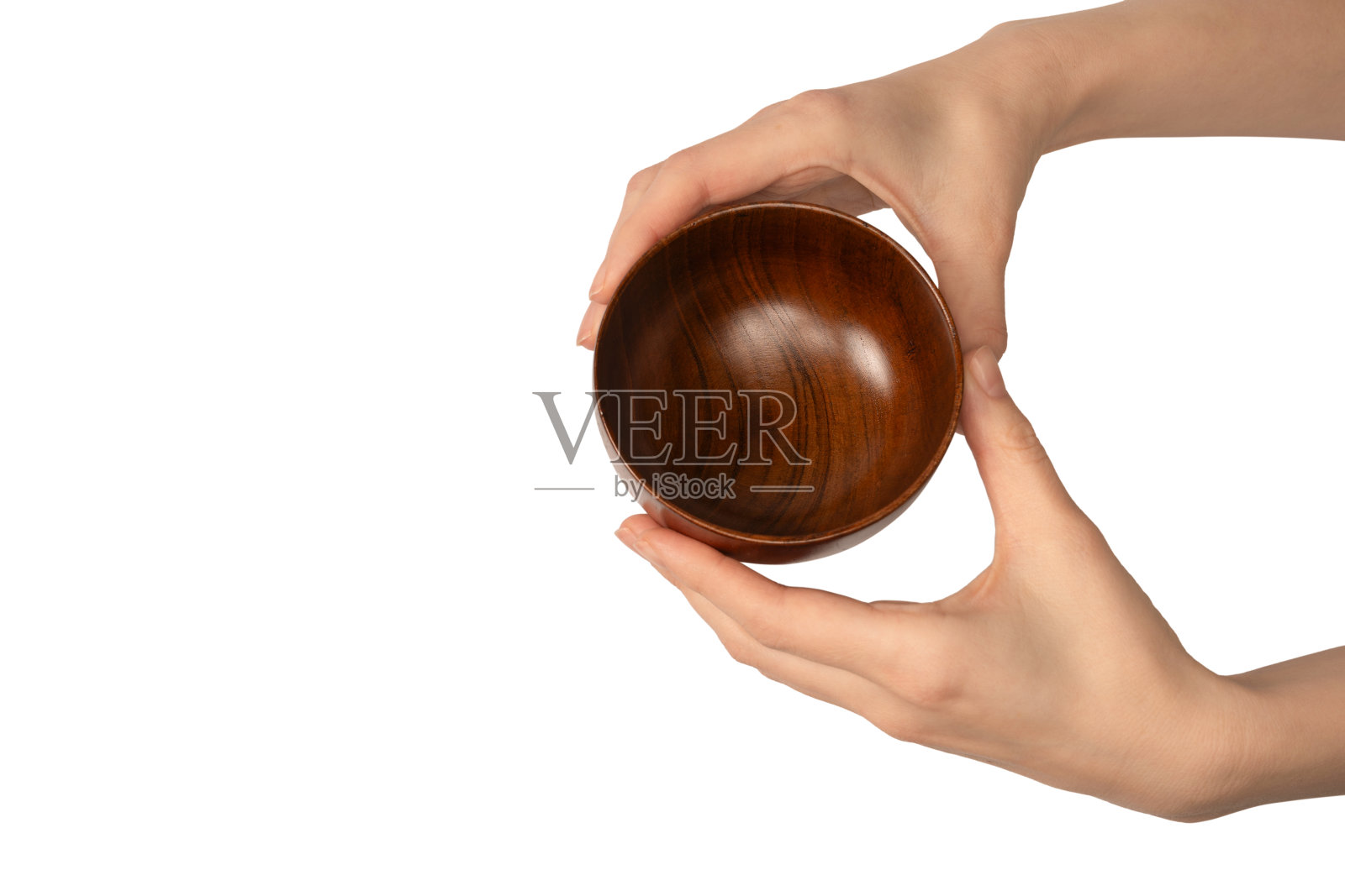 一个女人的手拿着一个木制的碗，孤立在白色的背景上。照片摄影图片