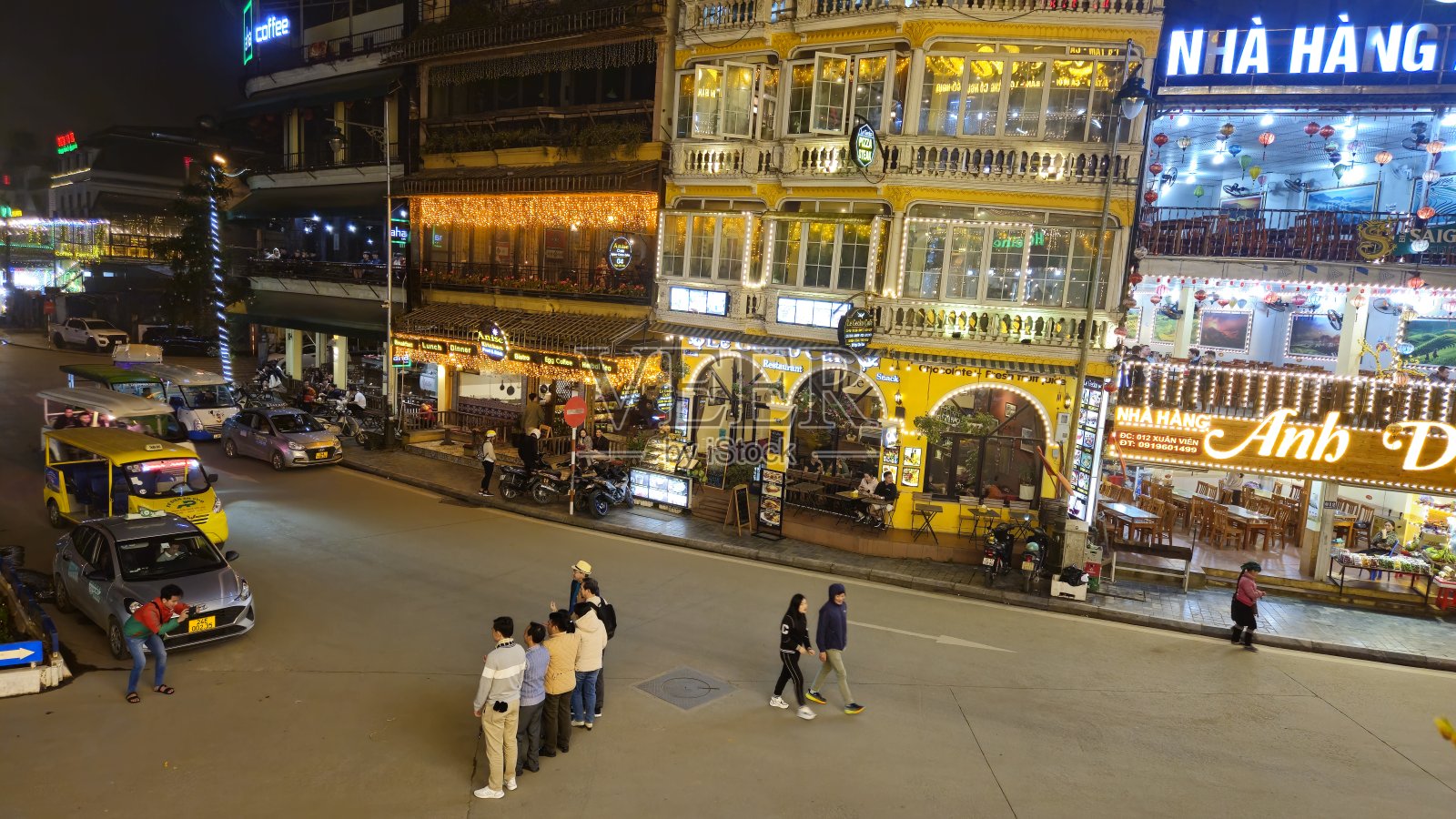 晚上，游客在越南萨帕镇的街道上参观和拍照。照片摄影图片