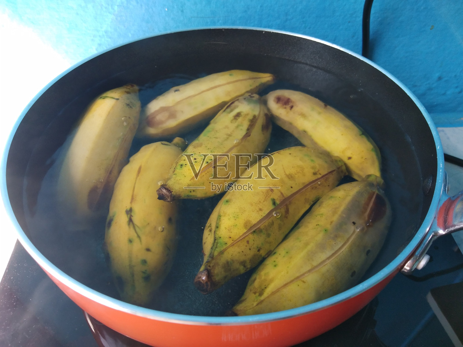 成熟的黄香蕉用煎锅在热水中煮熟。照片摄影图片