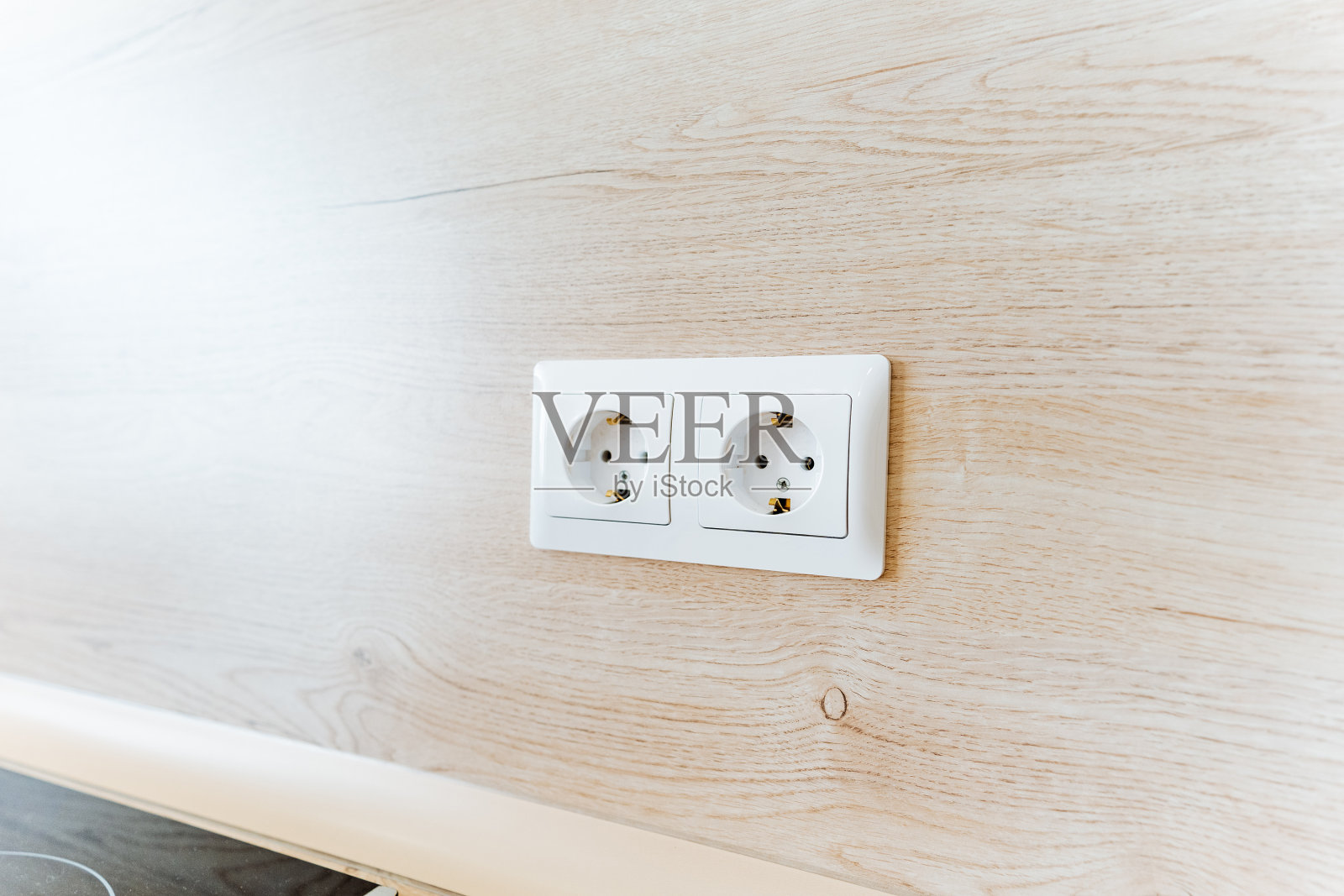 两个白色墙壁插座安装在硬木墙上照片摄影图片