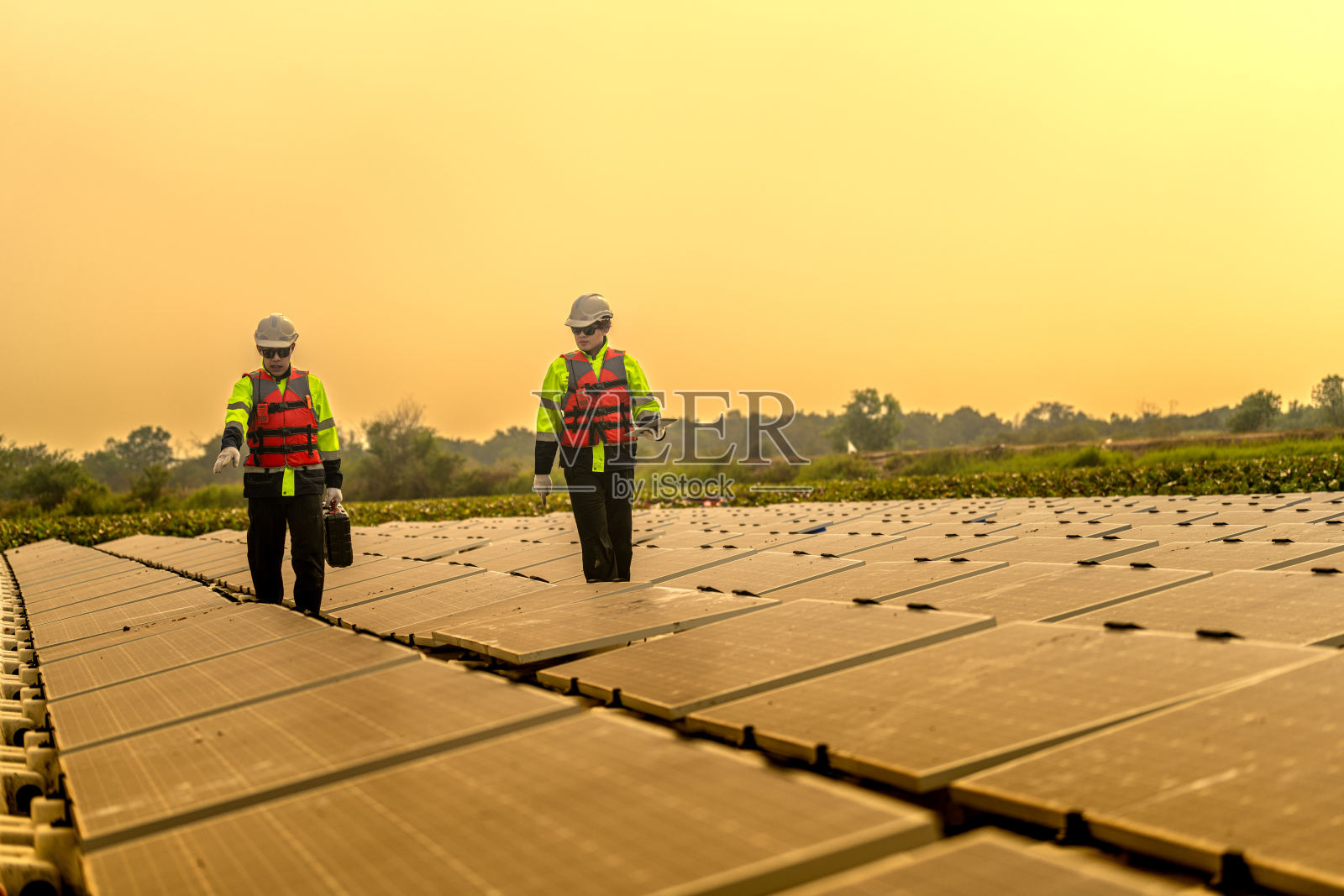 男工人修理水上漂浮的太阳能电池板。工程师在现场建造漂浮的太阳能电池板。未来生活的清洁能源。工业可再生能源的绿色动力。照片摄影图片