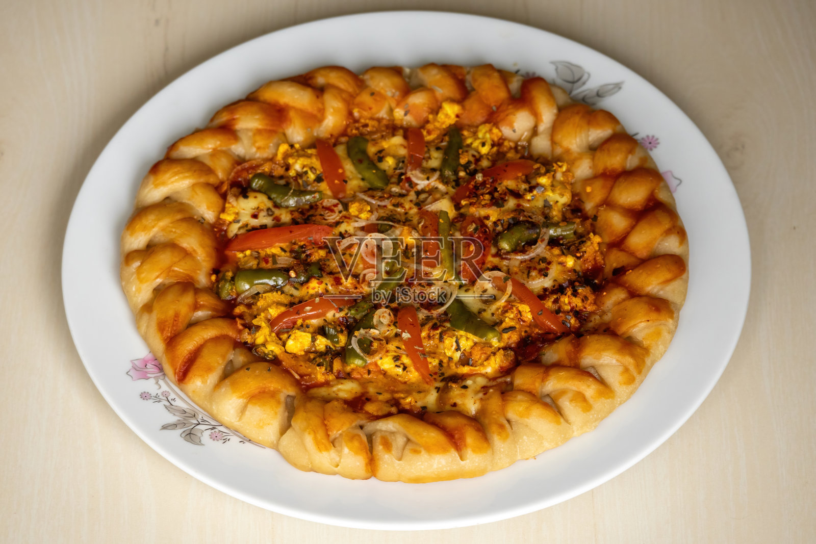 美味的鸡蛋披萨装在木制背景的白色盘子里。自制健康食品。照片摄影图片