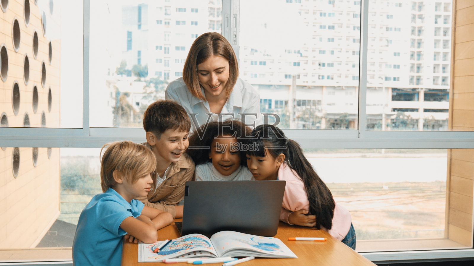 可爱的女孩编程系统，而周围的老师和朋友。博学。照片摄影图片