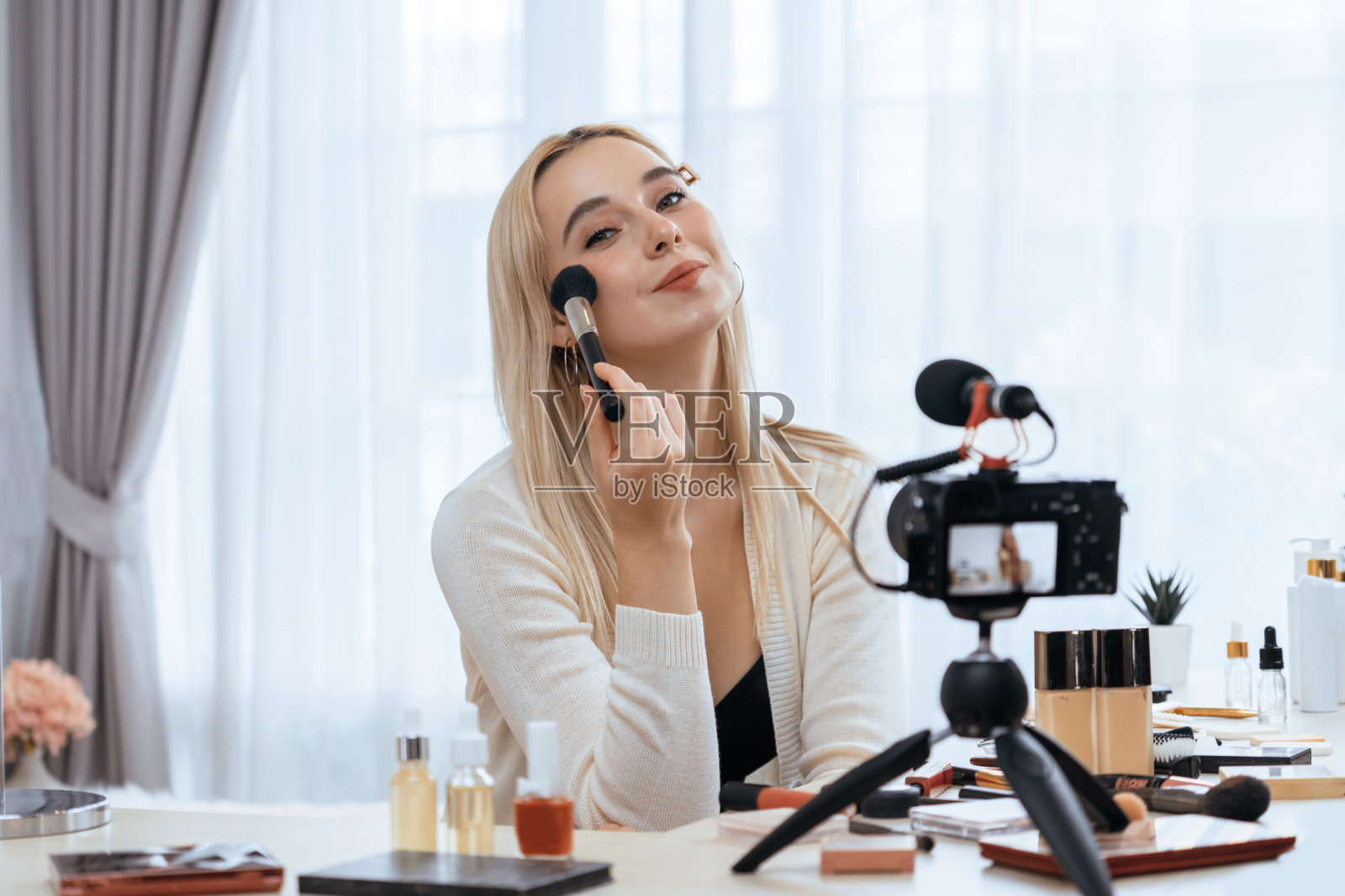 年轻女子制作美容美容教程视频内容。快乐无忧的照片摄影图片