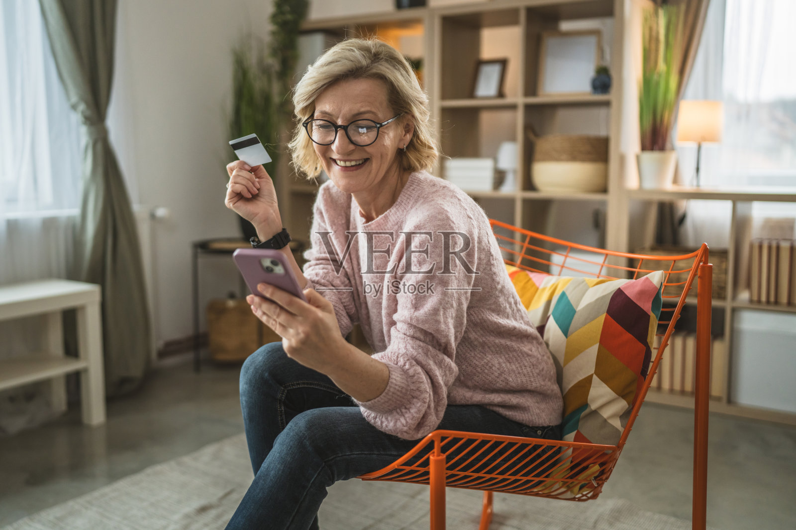 成熟女性白种女性持信用卡在家网购照片摄影图片