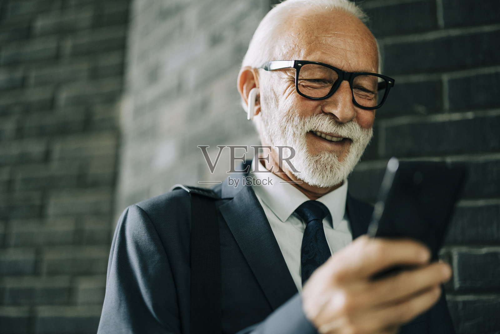 高级商人使用他的智能手机照片摄影图片