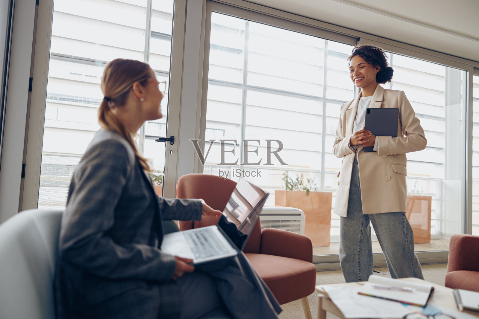 戴着眼镜的人力资源经理坐在办公室里向求职者做欢迎手势照片摄影图片