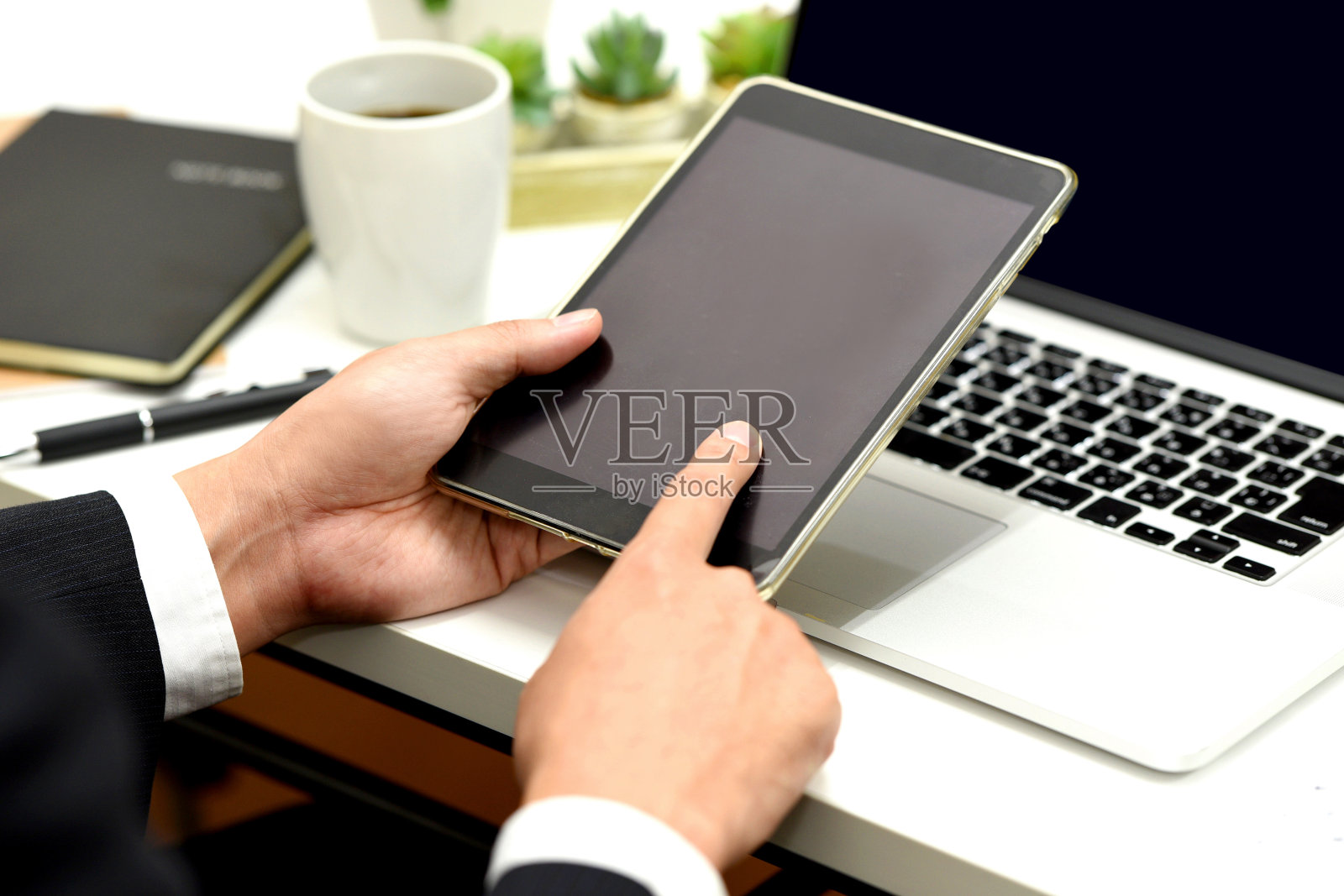 商人的手在笔记本电脑前操作平板电脑照片摄影图片