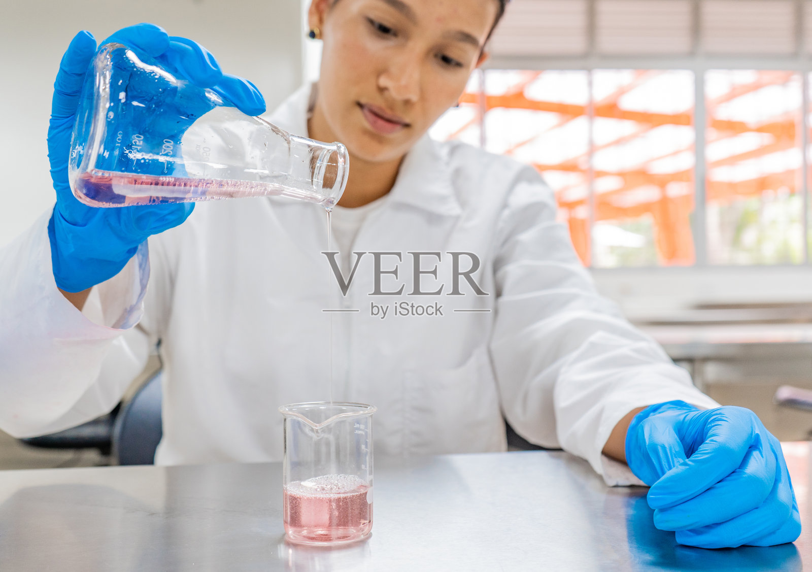 年轻的拉丁裔妇女在科学实验室里专心做实验照片摄影图片