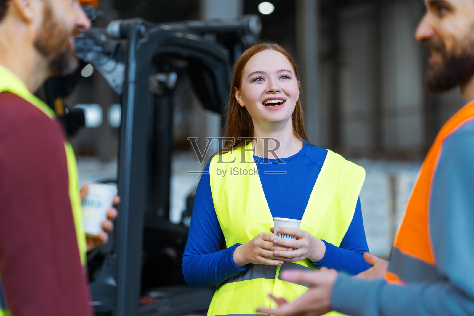 微笑，美丽，可爱，年轻的女人拿着一杯咖啡，放松，与同事交谈照片摄影图片
