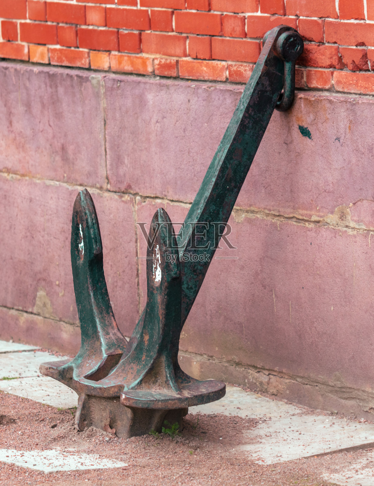 靠在砖房墙上的大金属锚照片摄影图片