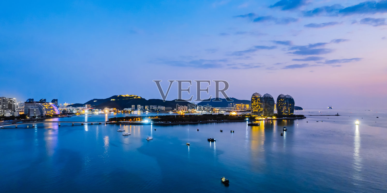 中国海南三亚湾凤凰岛和天际线的航拍夜景照片摄影图片