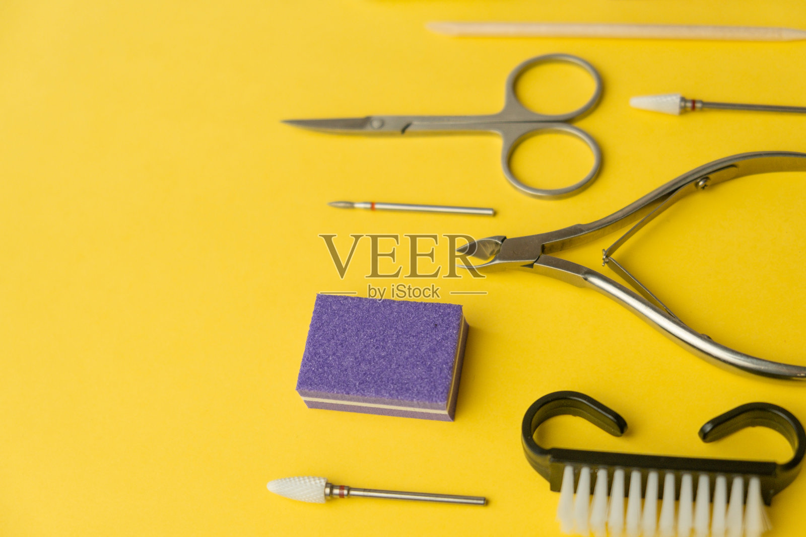 专业美甲工具在黄色背景。美甲套装。照片摄影图片