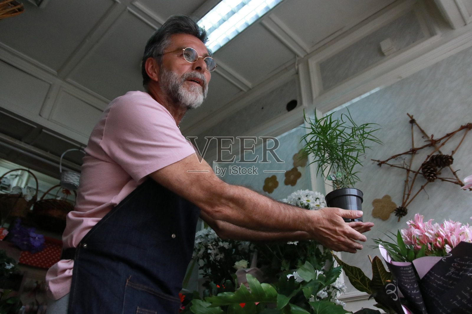 成熟的男人会照顾花店里的花照片摄影图片