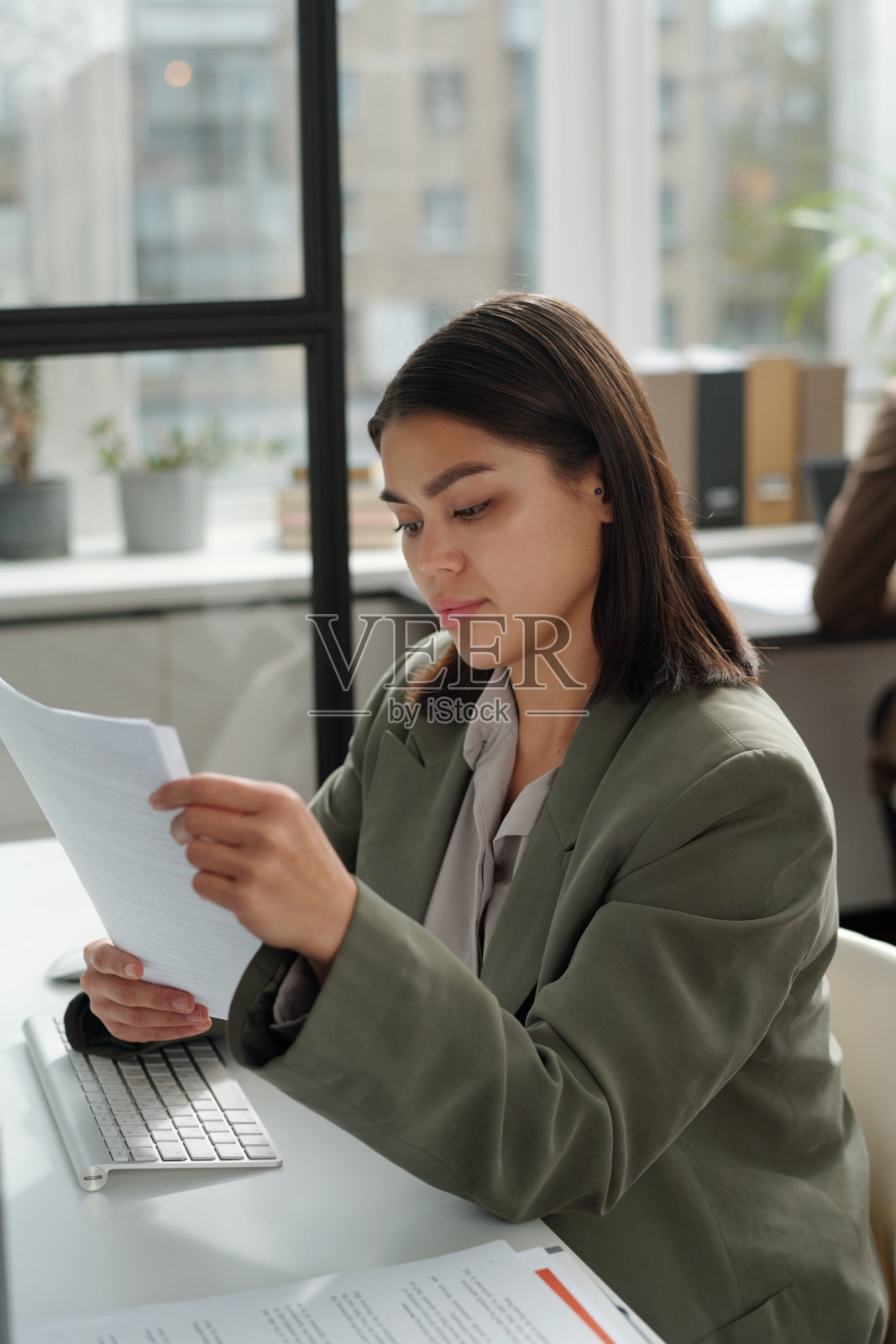 穿着正装的年轻女秘书正在翻阅财务文件照片摄影图片