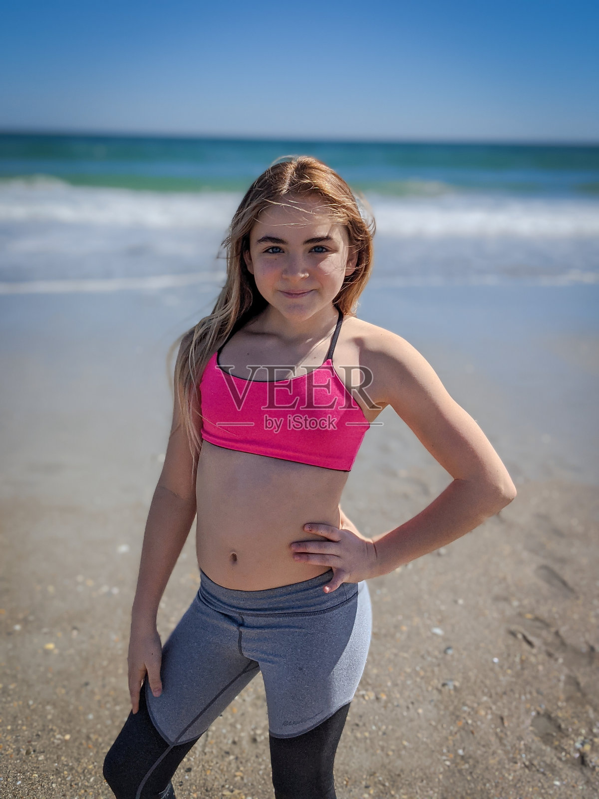 沙滩上穿粉色上衣的女孩照片摄影图片