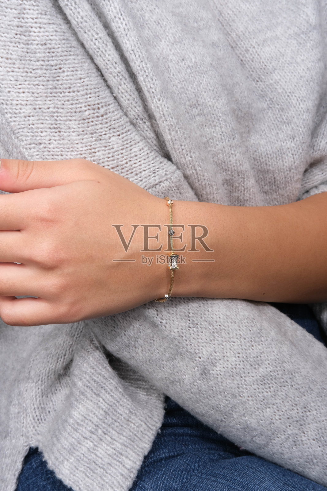 女人手里拿着金手镯，照片摄影图片