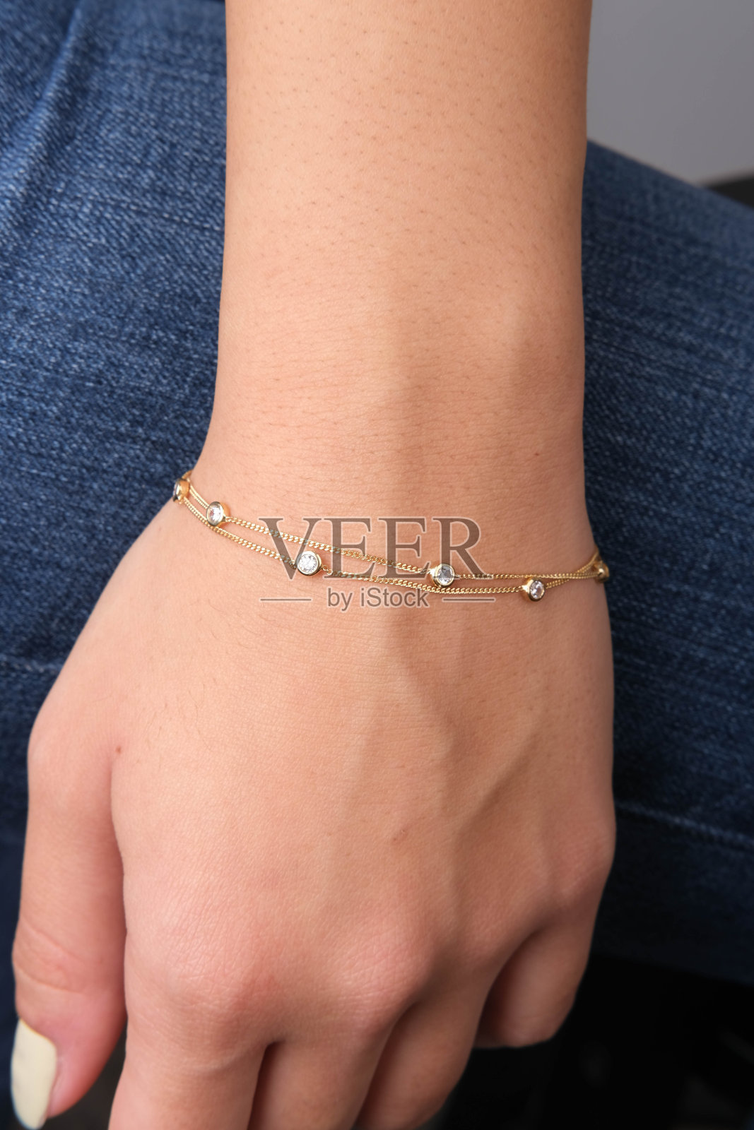 女人手里拿着金手镯，照片摄影图片