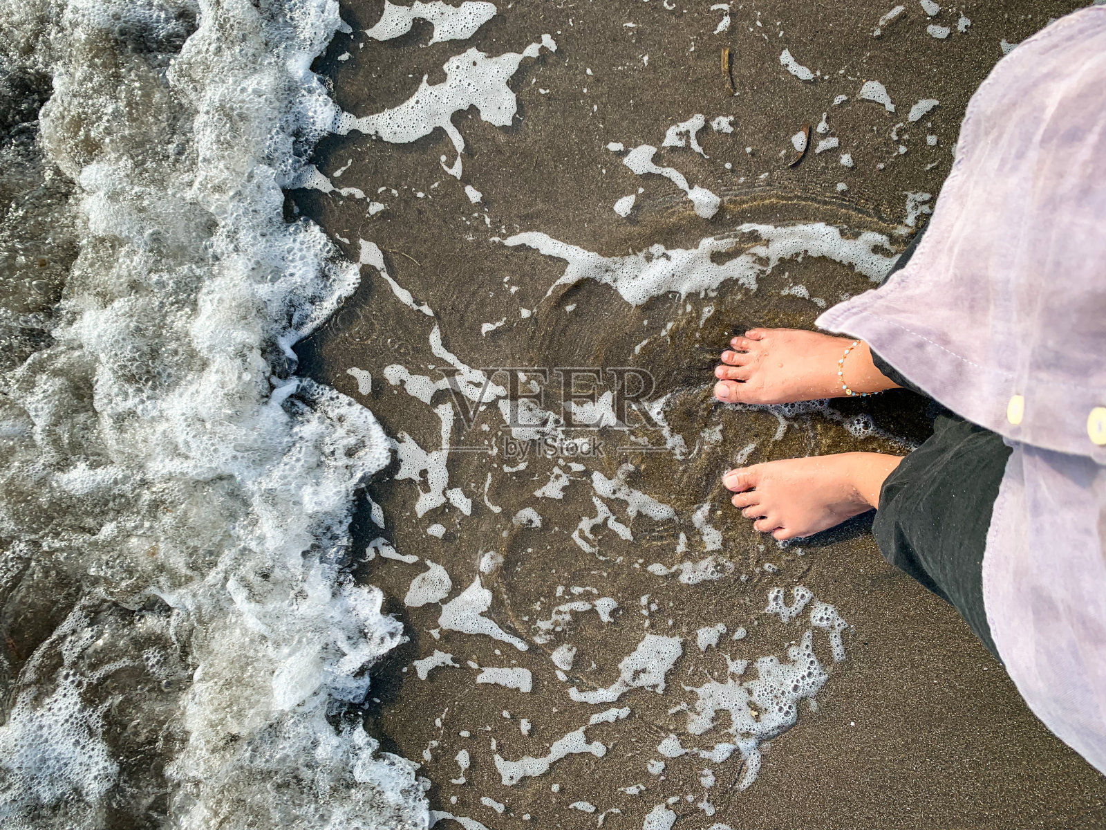 赤脚在沙滩上，脚踏理念。照片摄影图片