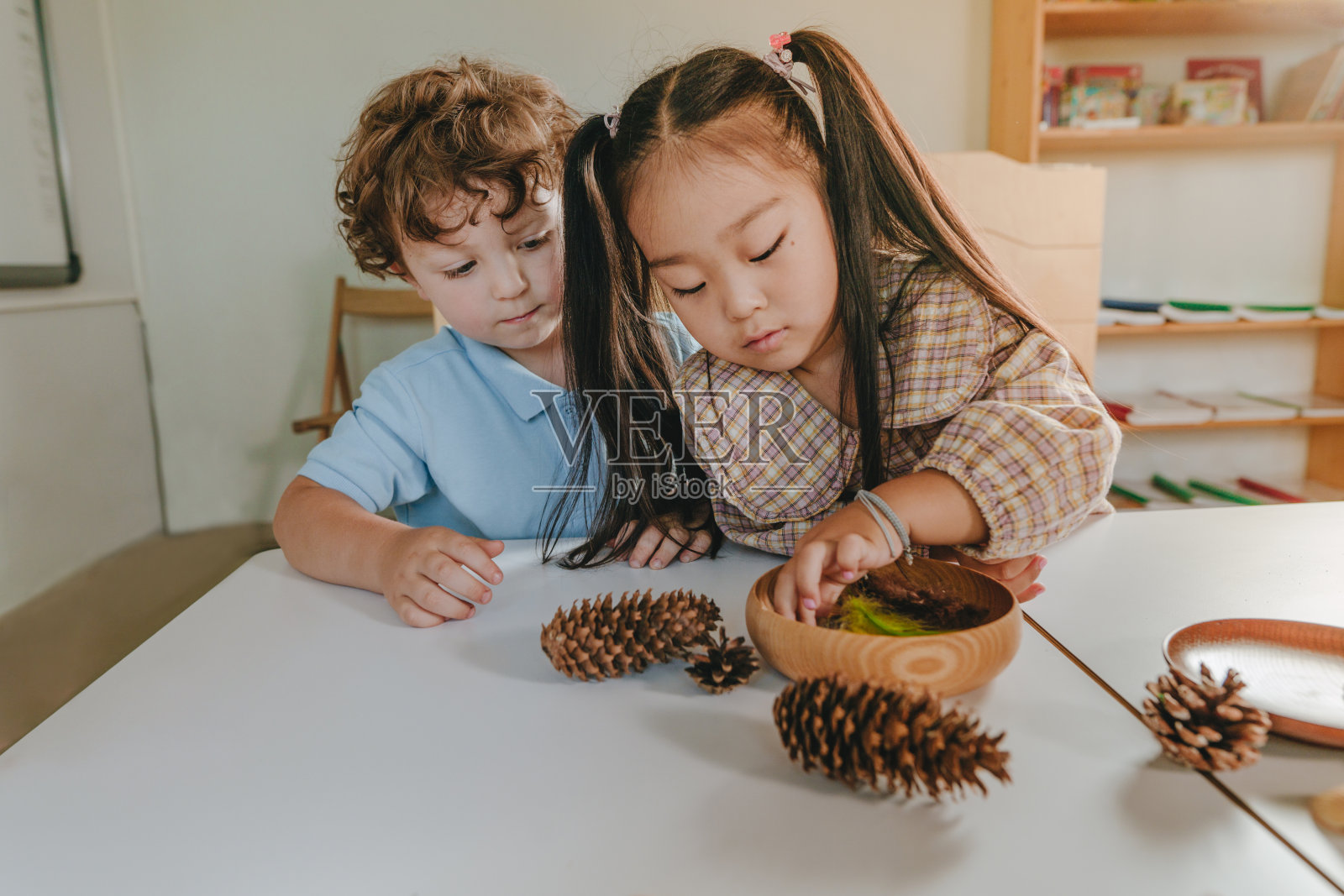 男孩和女孩在幼儿园玩天然玩具照片摄影图片